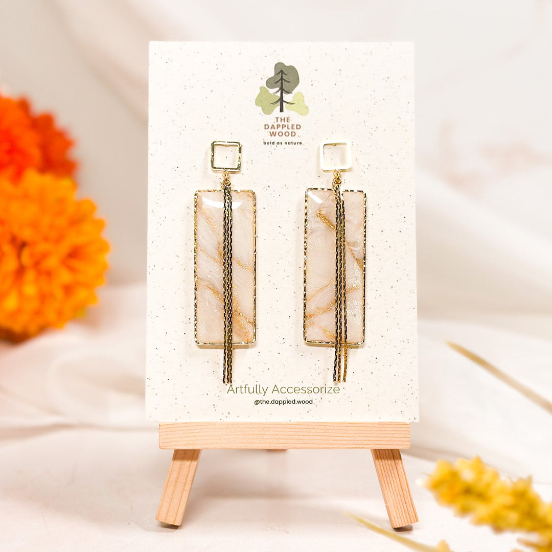 The Dappled Wood Ivory Coast large rectangle earrings, framed with a bold yet lightweight design, suspended on hollow square posts. A sophisticated geometric accent.