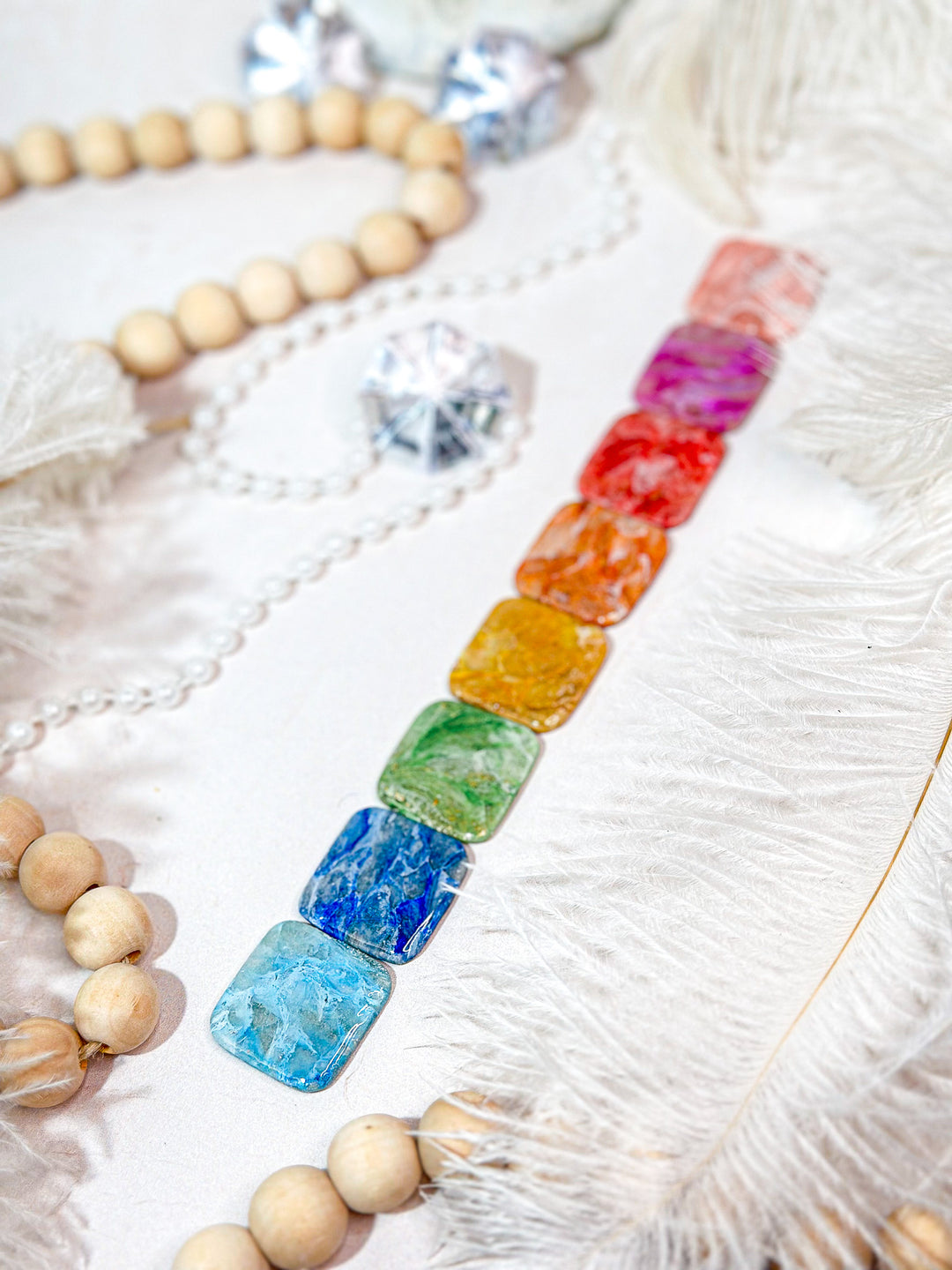 Example of color swatches for The Dappled Wood’s custom bridal jewelry, showcasing a range of vibrant faux stone options in a cascading rainbow arrangement. Perfect for personalized wedding accessories.