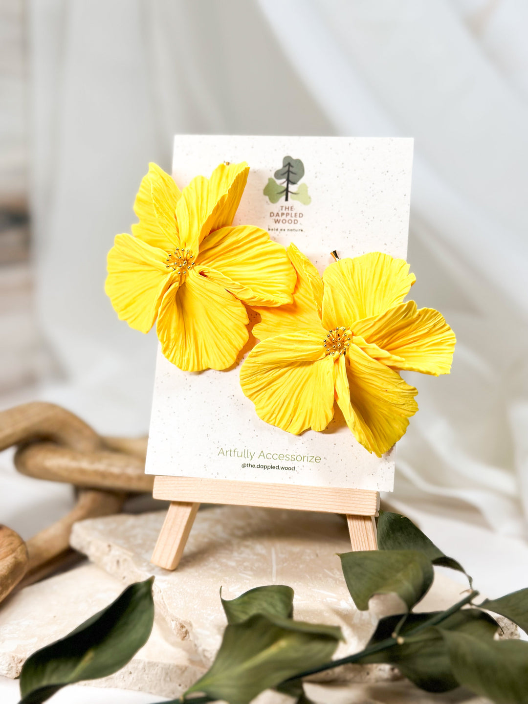 XL bright yellow handcrafted polymer clay flower earrings displayed on an easel from The Dappled Wood’s Burgeoning Blossoms Spring 2024 collection.