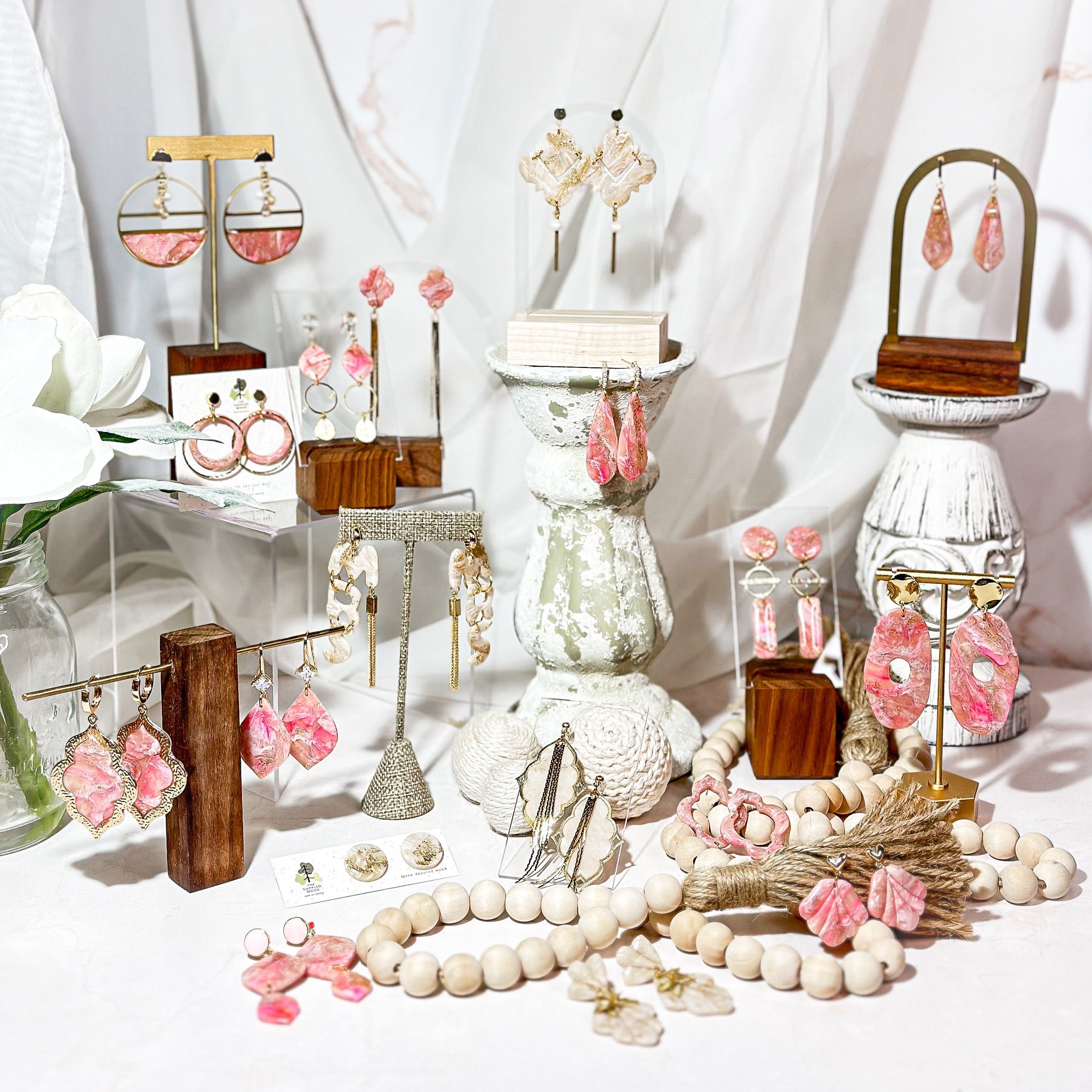 A display of handcrafted pink polymer clay wedding accessories—hair pins, lapel pins, cuff links, and rings—from The Dappled Wood’s Bridal Styles 2024 collection.