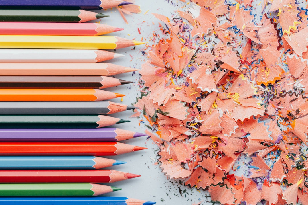 Close-up of colored pencils and shavings, representing The Dappled Wood’s Art Baubles collection of original artwork and print-on-demand items.