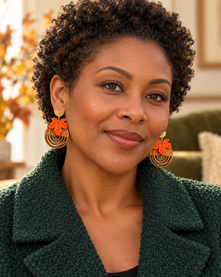 Black woman wearing a pair of Arden maple leaf and real wood statement earrings