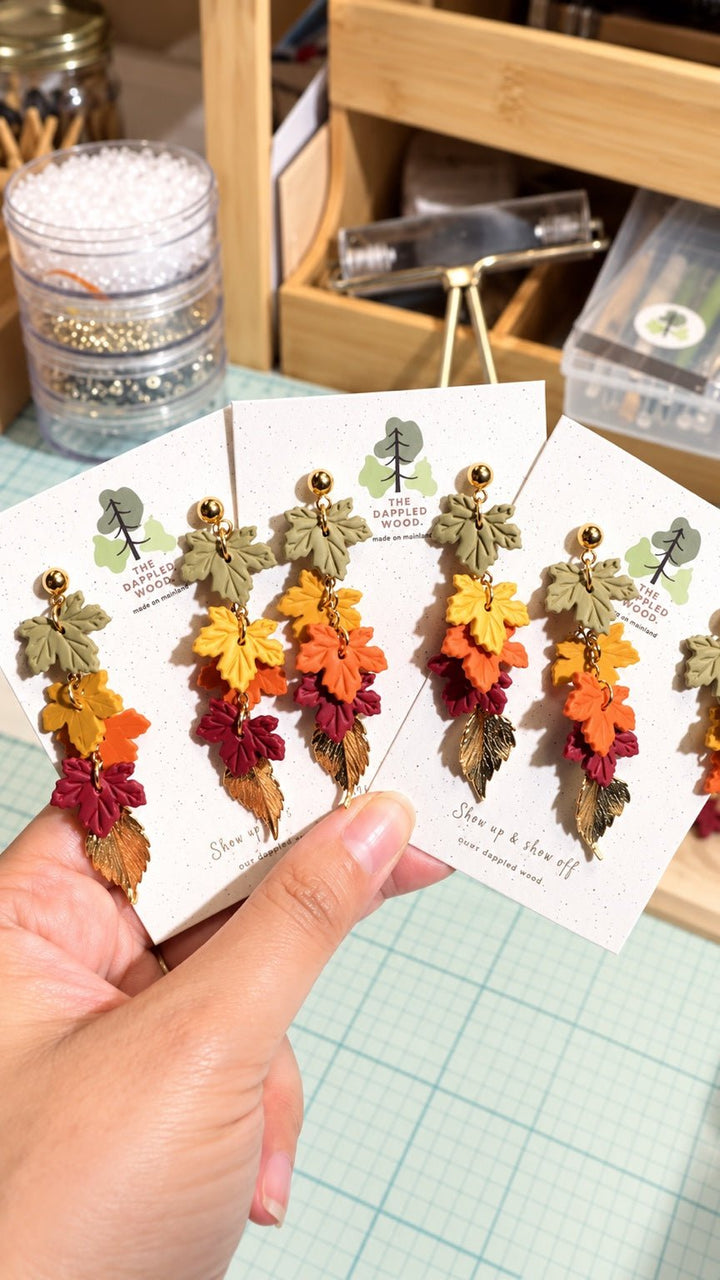 Audra cascading fall leaf earrings by The Dappled Wood in olive green, golden yellow, orange, burgundy, and antique gold.