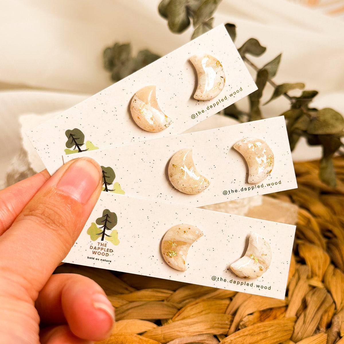 Three pairs of Aylin mini crescent moon studs showing unique Ivory Coast faux stone marbling and gold flecks