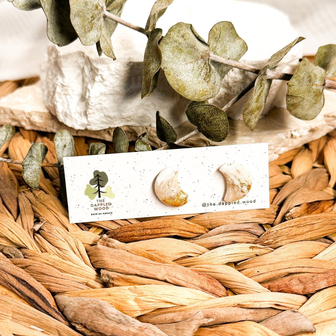 Aylin mini crescent moon stud earrings in ivory faux stone with gold flecks on an earring card