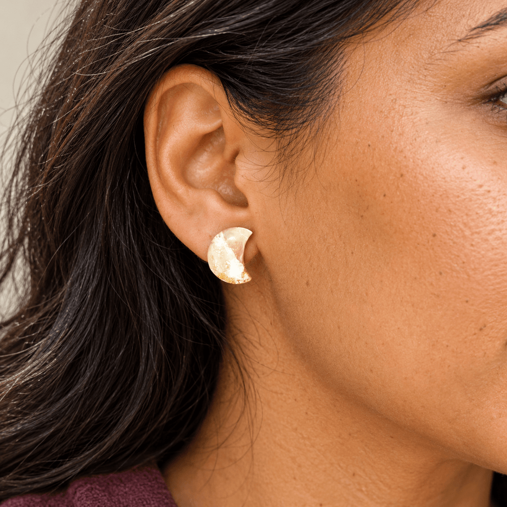 Model wearing Aylin mini crescent moon studs in creamy Ivory Coast faux stone with gold flecks