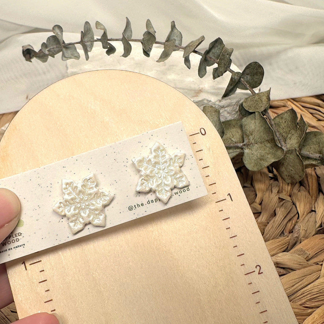 Blanche stud earrings beside a ruler showing size and scale