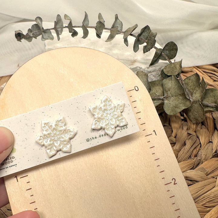 Blanche stud earrings beside a ruler showing size and scale