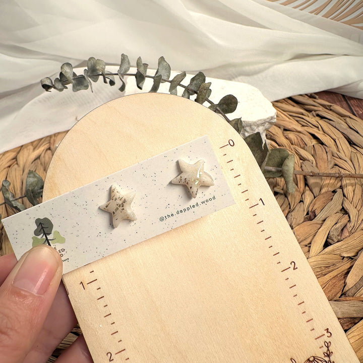 Estelle stud earrings beside a ruler showing size and scale