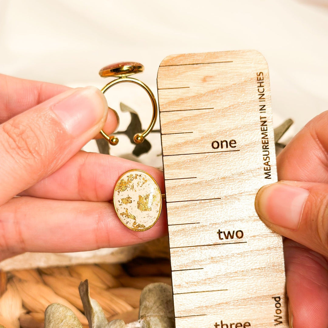 Ivory and gold Gemma adjustable ring shown beside a ruler with its 20mm oval face and open band visible.