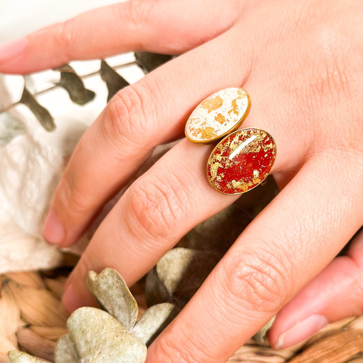 Ivory and red Gemma adjustable statement rings worn together on a hand to show scale and stacking.