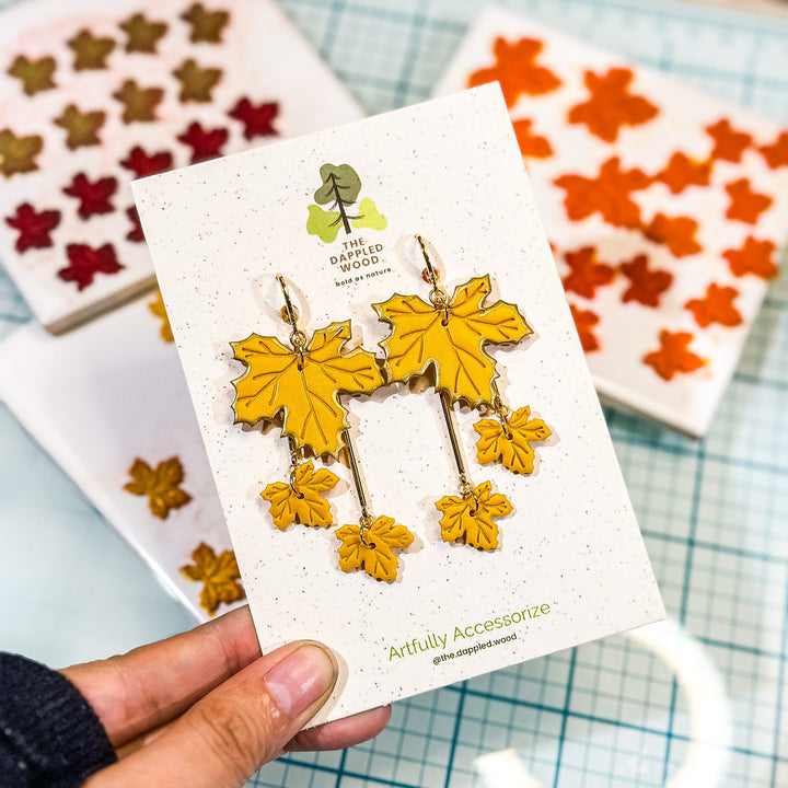 Laurel tiered maple leaf earrings in golden yellow with gilded edges on The Dappled Wood branded card