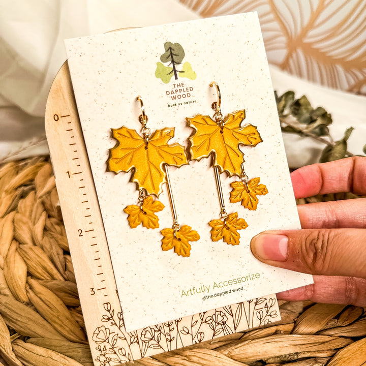 Laurel golden yellow tiered maple leaf earrings on branded card beside ruler showing 2 3/4 inch drop