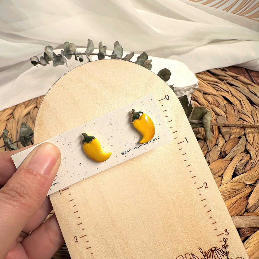 Leni stud earrings beside a ruler showing size and scale