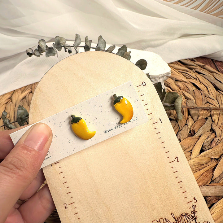 Leni stud earrings beside a ruler showing size and scale
