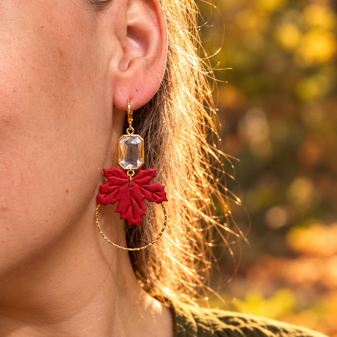 Model wearing Lucinda red maple leaf earrings with faceted glass gems in autumn light