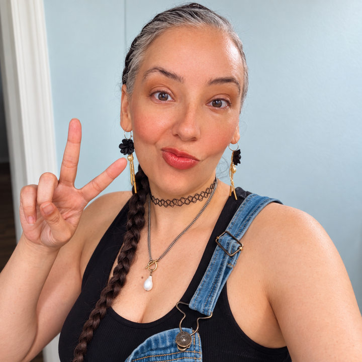Customer wearing black Martiza long tassel and pearl flower earrings by The Dappled Wood.