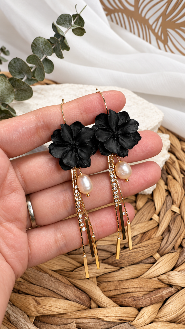 Close-up of black Martiza flower earrings with freshwater pearls, gold tassels, and CZ details by The Dappled Wood.