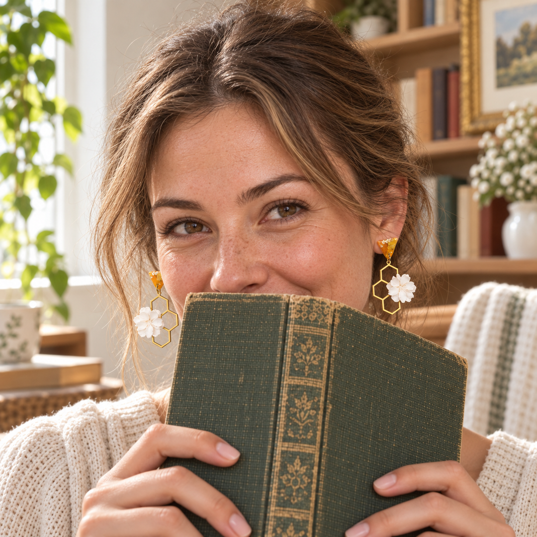 Woman wearing Melina honeycomb flower earrings while reading in a sunny room