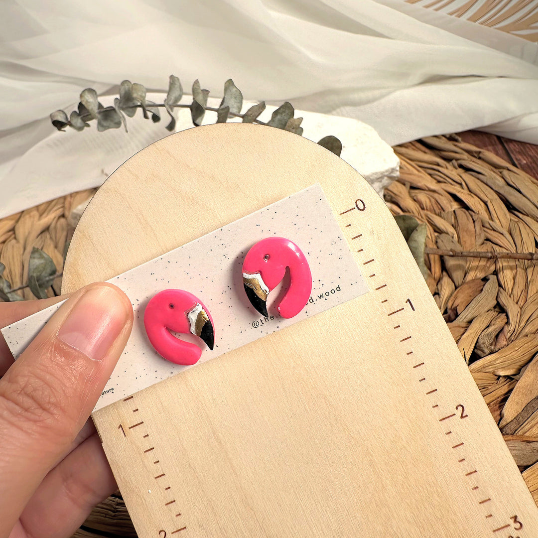 Tallulah flamingo stud earrings photographed beside measuring tape for scale