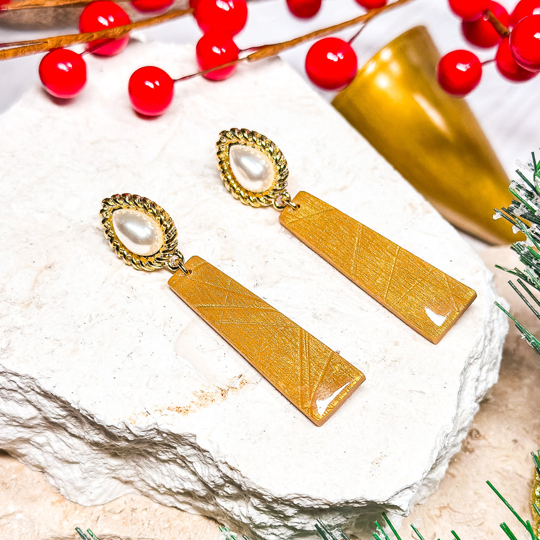 The Dappled Wood Holly Jolly large faux pearl post earrings with a gold textured dangle, perfect for a holiday party look.