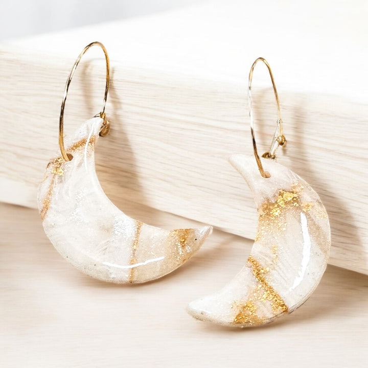 The Dappled Wood Ivory Coast crescent moon hoop earrings, handcrafted from polymer clay in a soft neutral shade with 18K gold-filled hoops. A lightweight, hypoallergenic design perfect for effortless elegance.