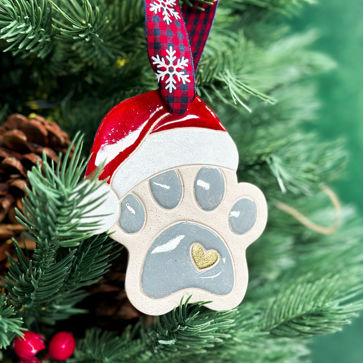  Handmade paw print ornament with a red Santa hat, perfect for pet lovers.