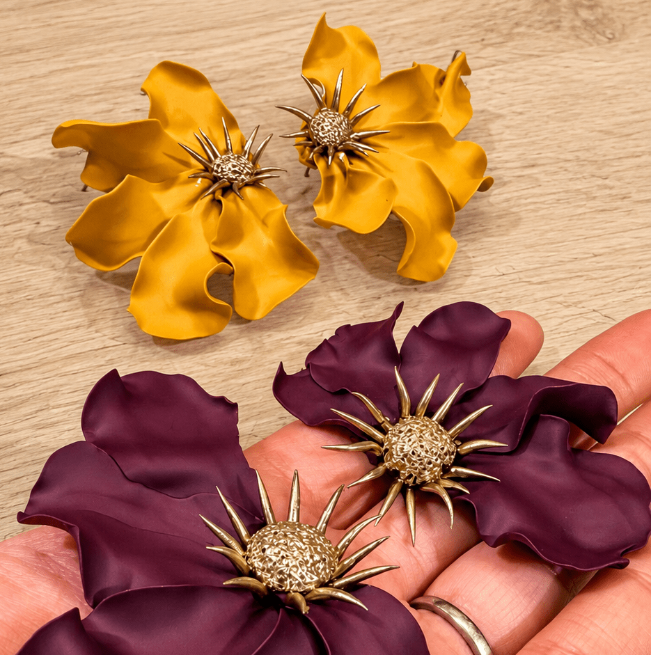Abundance workshop flower earrings in sunflower yellow and blackberry purple with gold centers.