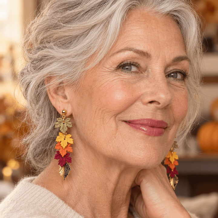 Older woman wearing Audra cascading fall leaf earrings in rich autumn colors.