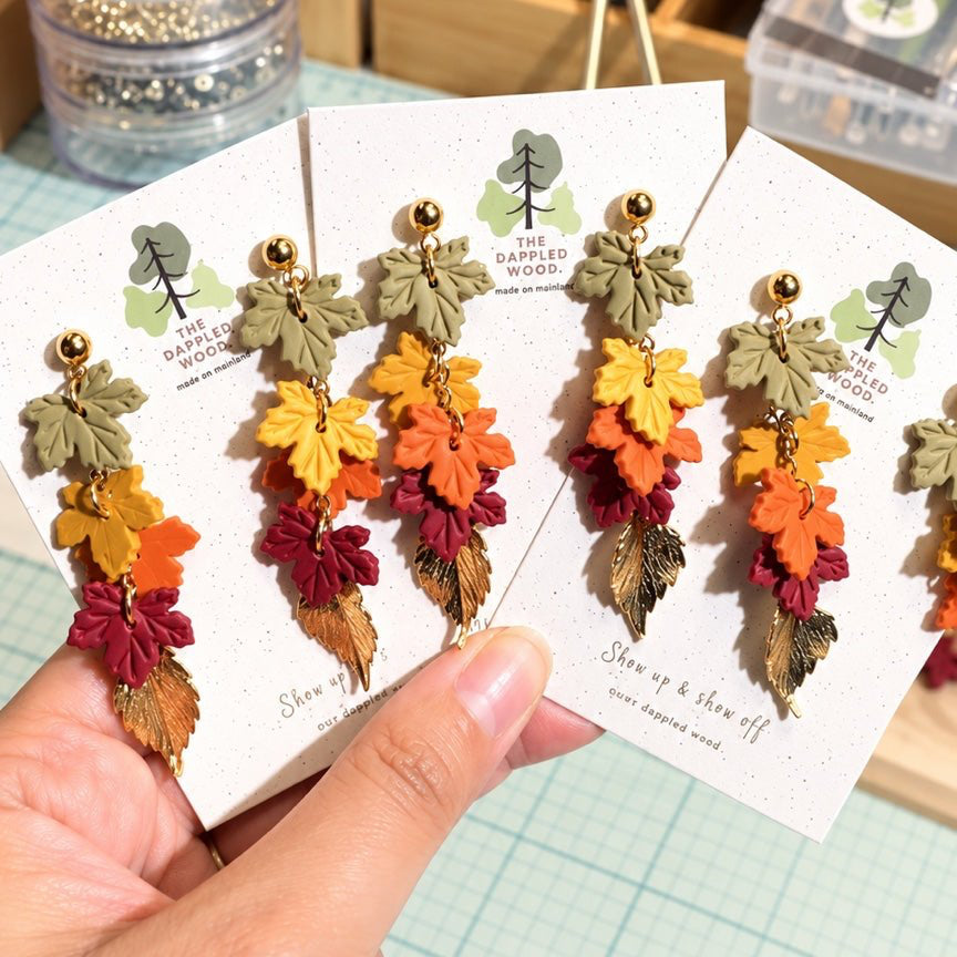 Audra cascading leaf earrings in olive, yellow, orange, burgundy, and antique gold.