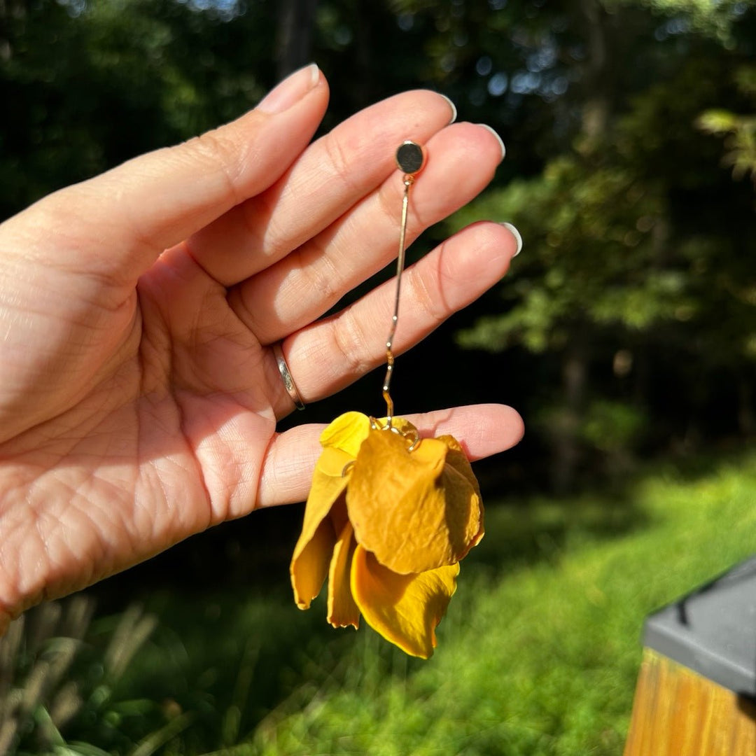 Close-up of Delilah Yay for Yellow long petal drop earrings showing sculpted clay petals and a wavy gold connector.