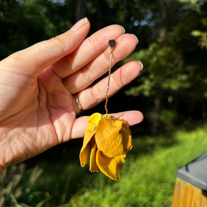Close-up of Delilah Yay for Yellow long petal drop earrings showing sculpted clay petals and a wavy gold connector.