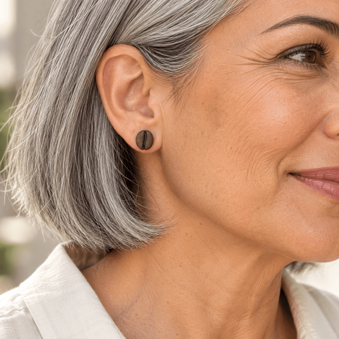AI-generated styling preview of a silver-haired model wearing a Demi coffee bean stud; scale is illustrative