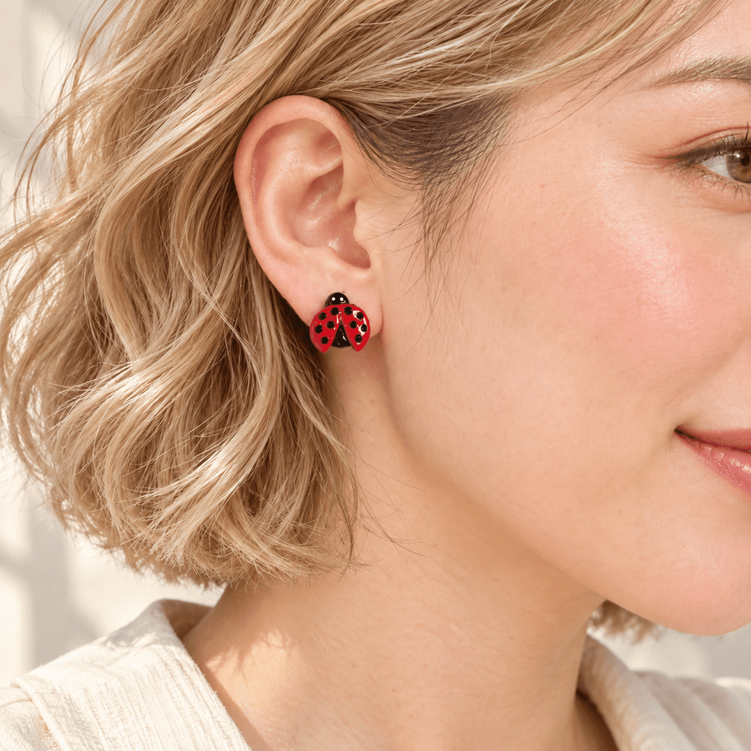 AI-generated styling preview of Dotty ladybug studs on a model with a natural blonde wavy bob; scale illustrative.