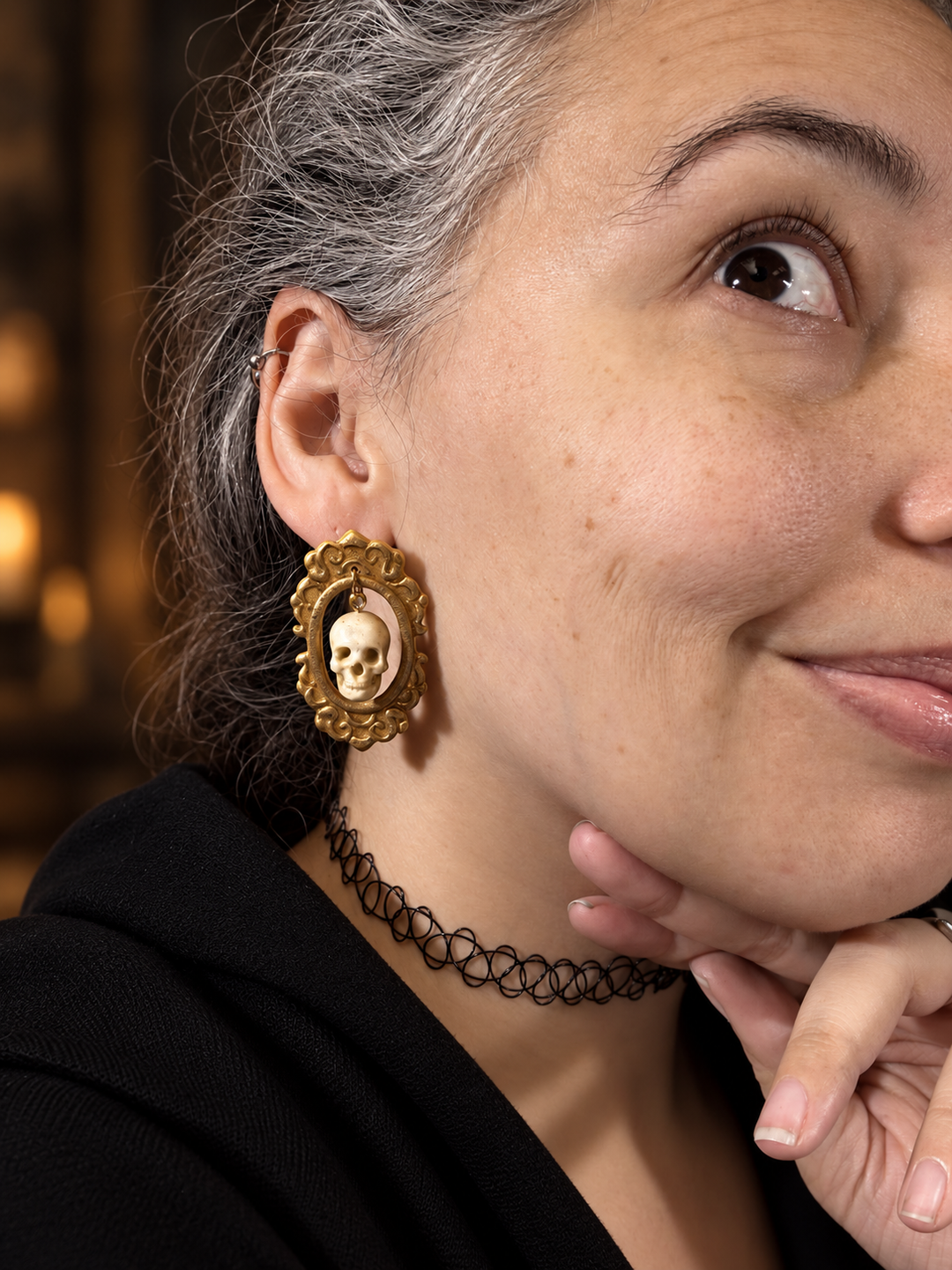 Woman wearing Drusilla antique gold framed skull statement earrings