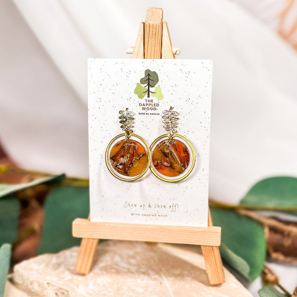 Gold leaf post earrings with a framed circle drop from the Fallen Leaves collection by The Dappled Wood. Lightweight, hypoallergenic jewelry inspired by autumn foliage.