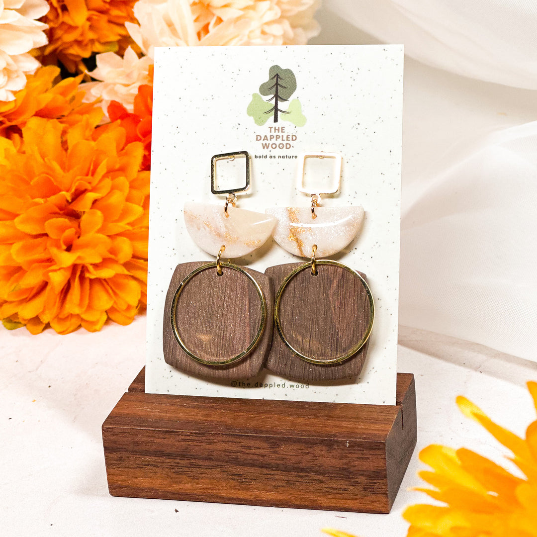 The Dappled Wood Ivory Coast collection from Fall 2024 featuring cream and gold faux marble with faux wood polymer clay design, lightweight for sensitive ears.