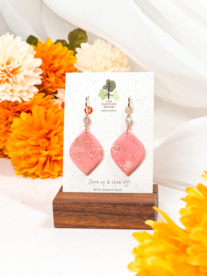 Soft diamond-shaped earrings with a micro heart charm on a small gold huggie, designed for The Dappled Wood’s Pinktober collection.