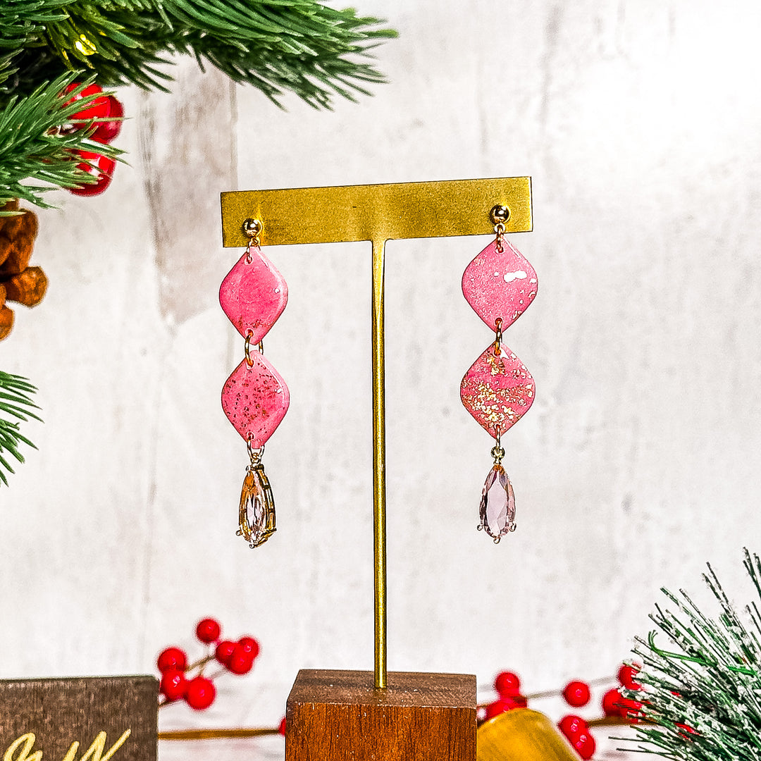 Double diamond-shaped pink earrings with a delicate pink glass gem, a stylish tribute to breast cancer awareness by The Dappled Wood.