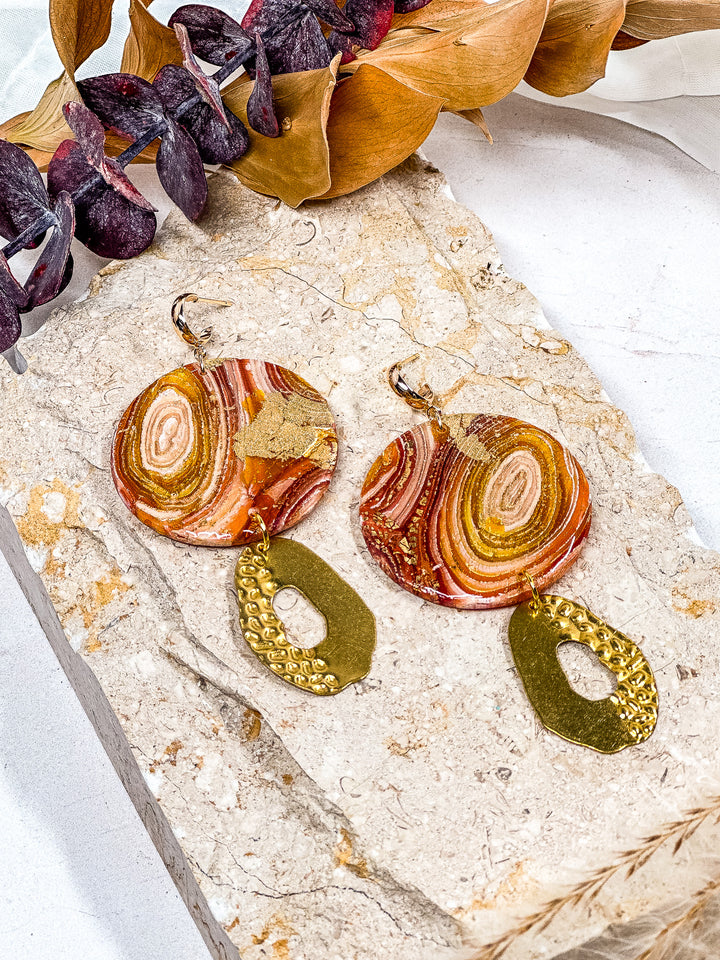 The Dappled Wood’s Traces of Tangerine faux orange agate earrings in an XL circle design with a half dappled charm and small gold huggie post. Handmade hypoallergenic jewelry, made in Baltimore.