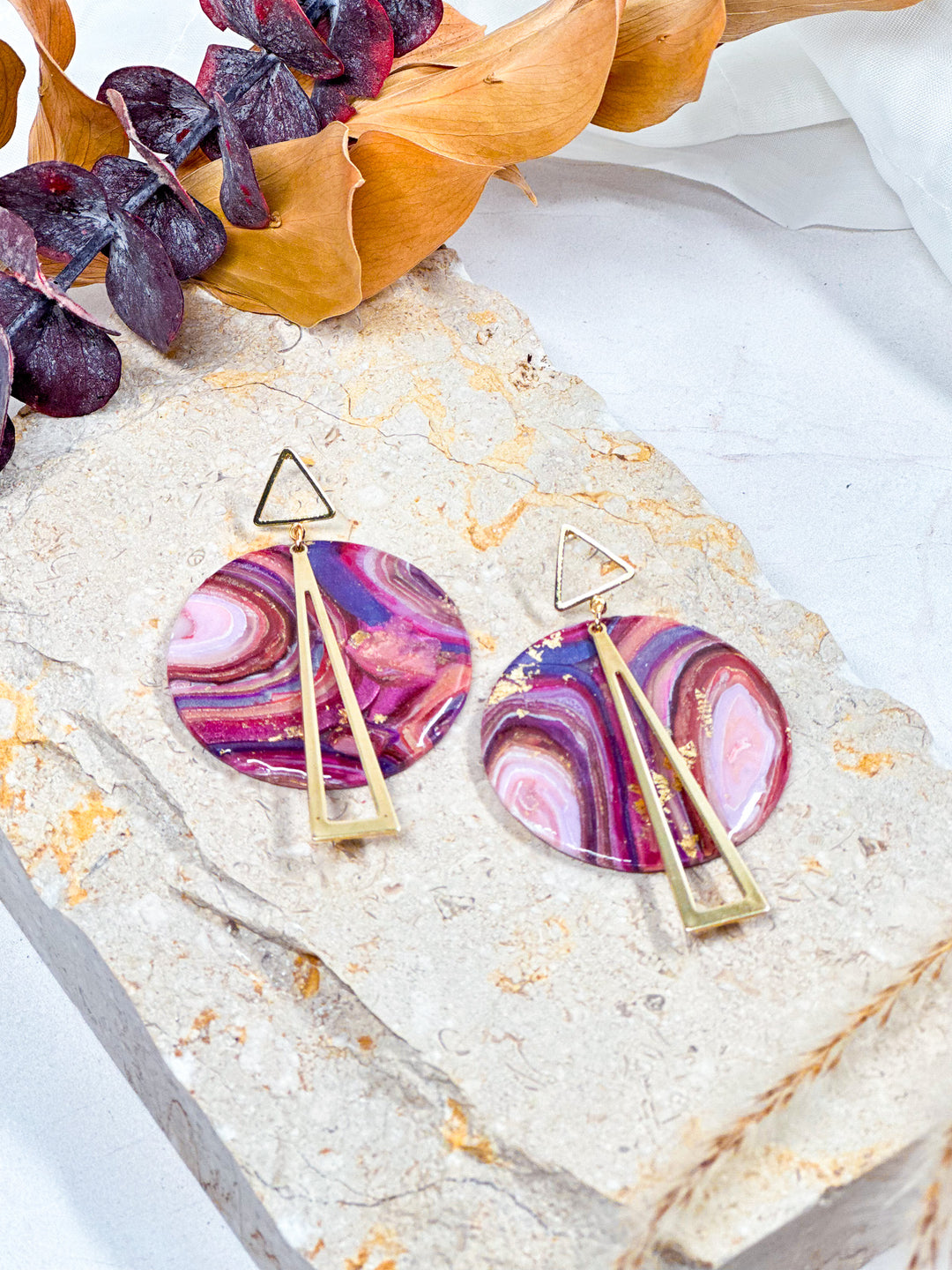 XL circle earrings from The Dappled Wood’s Veins of Violet collection, featuring faux purple agate, gold triangle charms, and hollow triangle posts. Handmade hypoallergenic jewelry.