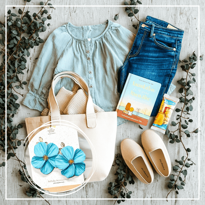 The Dappled Wood Fall 2025 Flora Aqua earrings styled in a calming flat lay with eucalyptus, casual blouse, jeans, tote, and slip-ons, handmade NuMomish statement jewelry symbolizing lightness and strength.