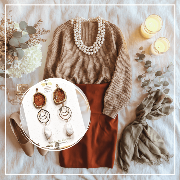 The Dappled Wood’s Rhea brick red and faux baroque pearl statement earrings styled with a brown sweater, brick red skirt, pearl necklace, scarf, candles, and flowers for a cozy Thanksgiving flatlay, Fall 2025
