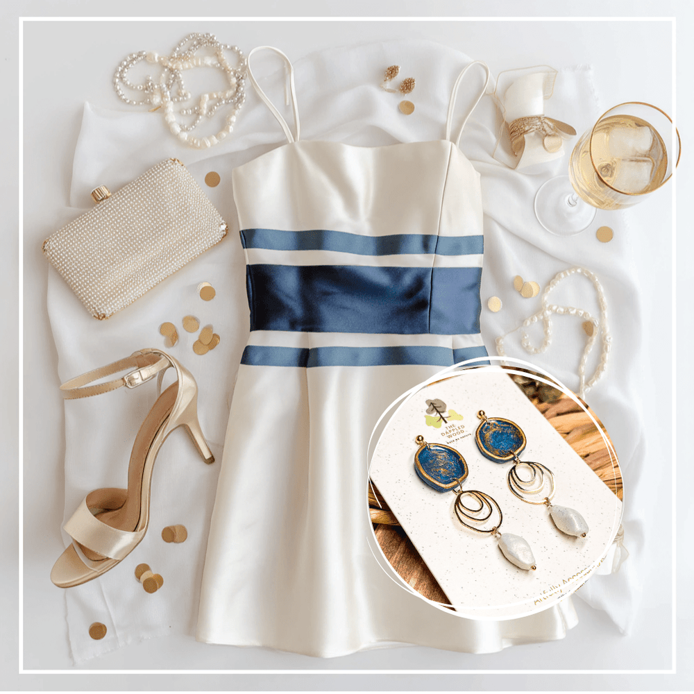 The Dappled Wood’s Rhea navy blue and faux baroque pearl statement earrings, shown with a cream and navy cocktail dress, pearl accessories, and champagne for an elegant holiday party look, Fall 2025