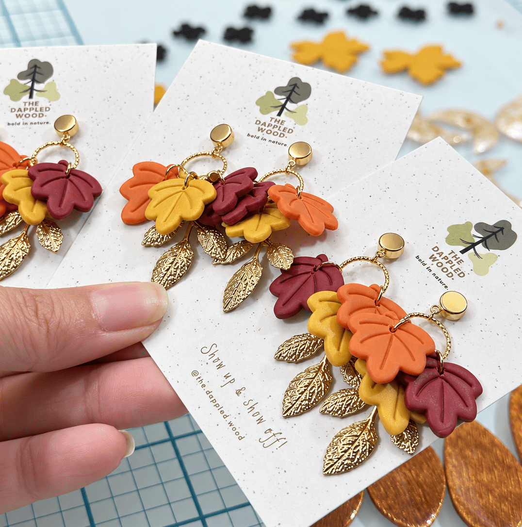 Fallon autumn leaf earrings in burgundy, mustard yellow, burnt orange, and textured gold.