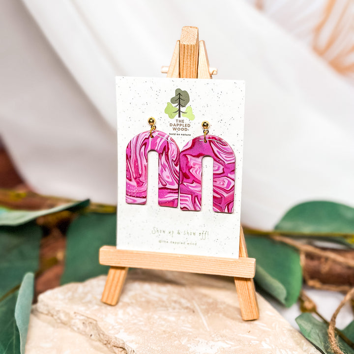 The Dappled Wood Hot Pink Mokume Gane polymer clay earrings from the Cupid's Cache collection in February 2024, featuring 18k gold-filled ball posts.