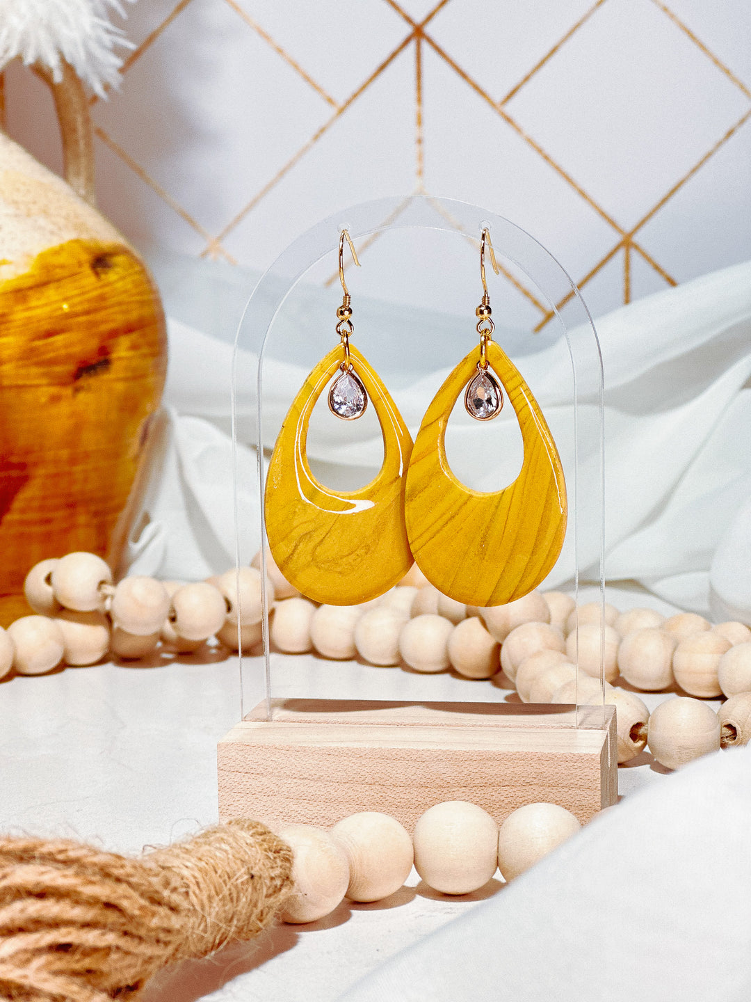 The Dappled Wood Marigold teardrop earrings. Mustard yellow statement earrings with a glass charm, handcrafted for a bold yet lightweight look. Features 18k gold-filled French hooks for a hypoallergenic and elegant finish.