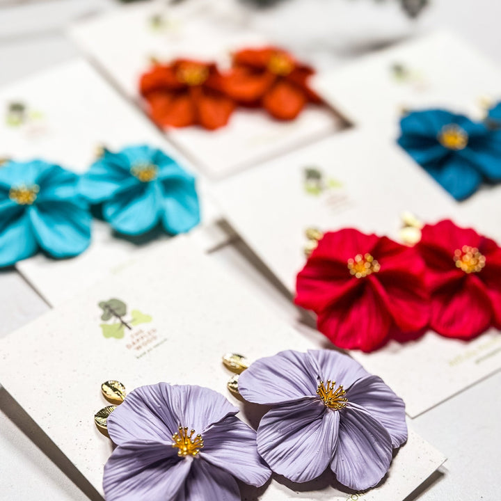 The Dappled Wood Fall 2025 Flora collection, limited edition Nu Momish handmade flower earrings in teal, lilac, tangelo.