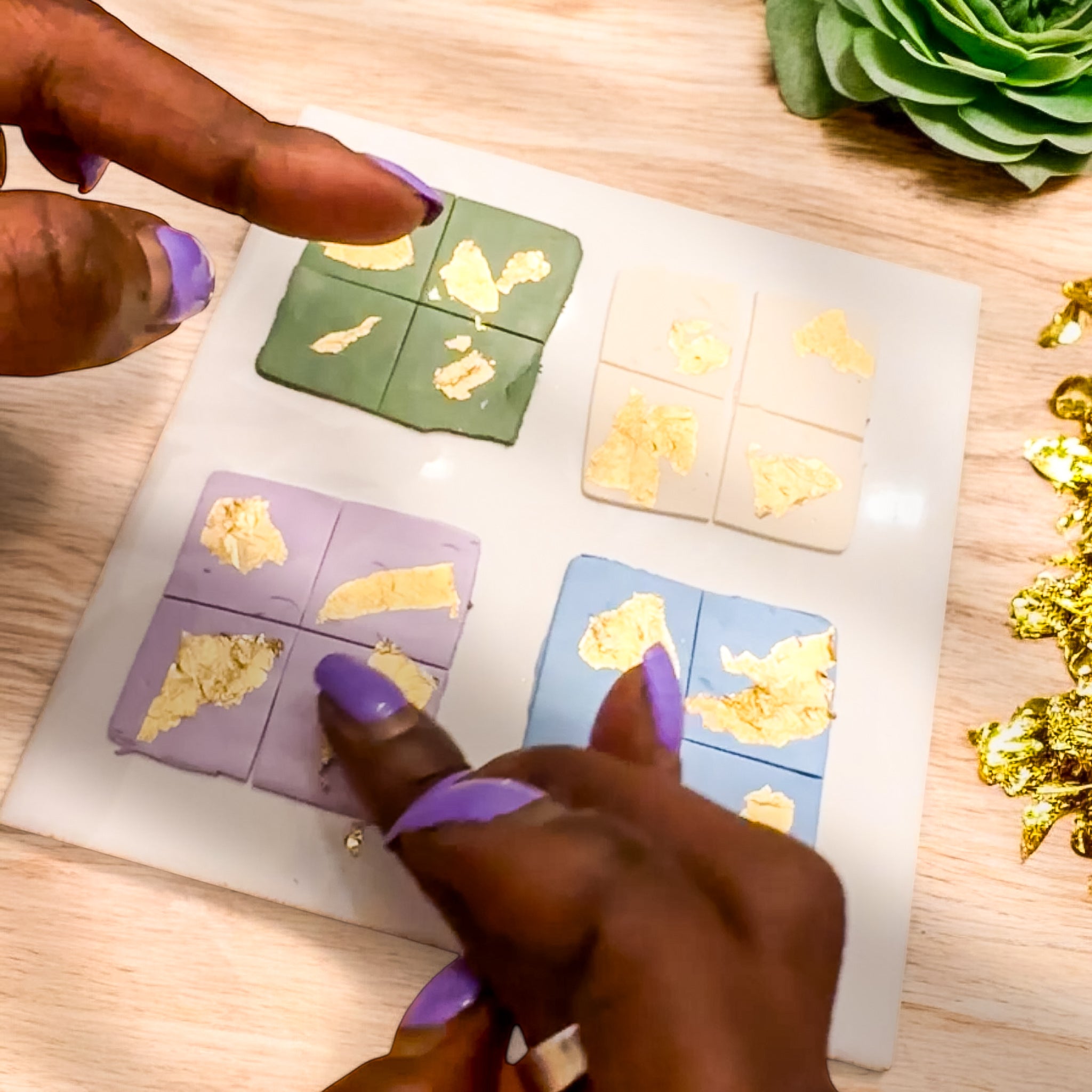 A participant adds gold leaf to colorful clay tiles in The Dappled Wood's art workshop focused on dopamine dressing. A vibrant art class and mindful thing to do in Baltimore.
