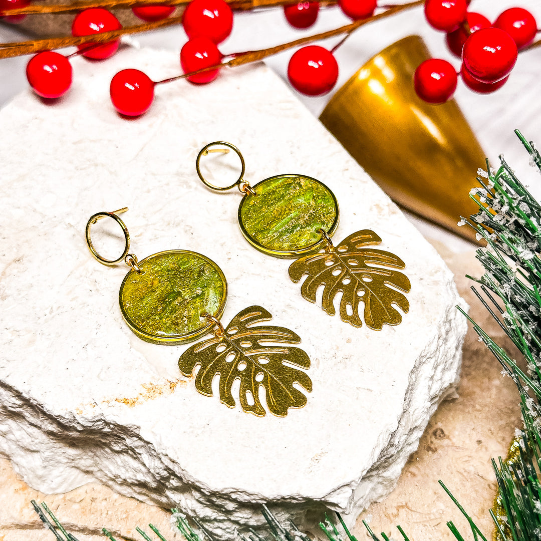 The Dappled Wood Melody earrings featuring faux peridot with Monstera leaf charms, lightweight statement jewelry inspired by nature.